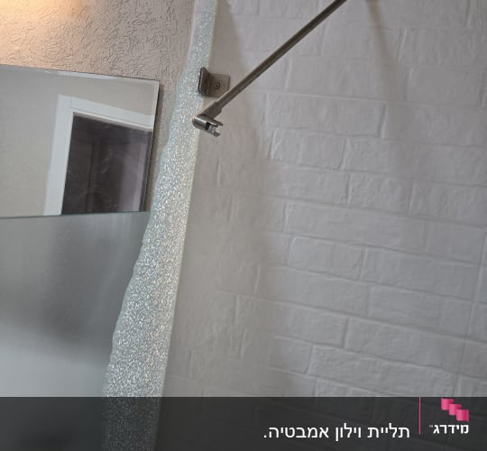 מוט מתכת מותקן על קיר עם אריחים לבנים